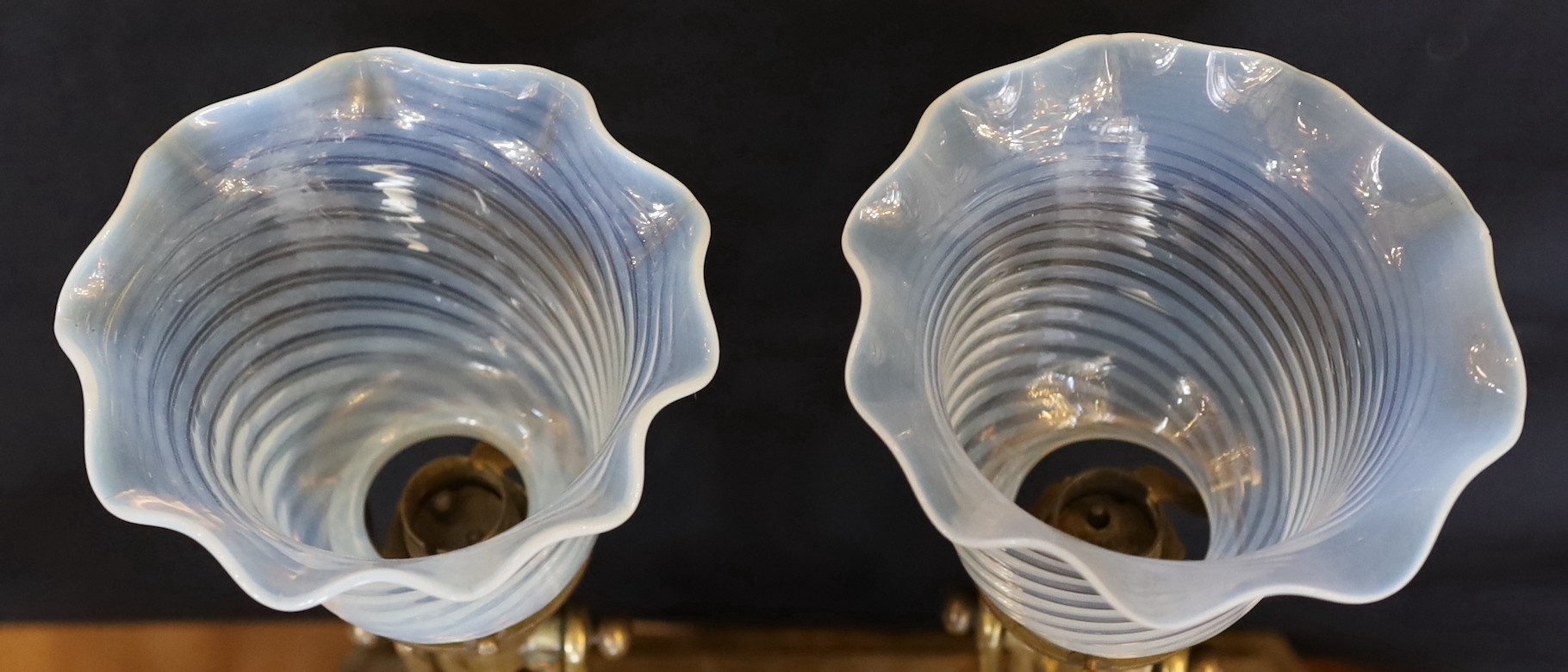 A pair of brass Pullman lamps with gimbal stems and Vaseline glass shades, modelled for wall mounting or freestanding, height to top of shade 40cm
